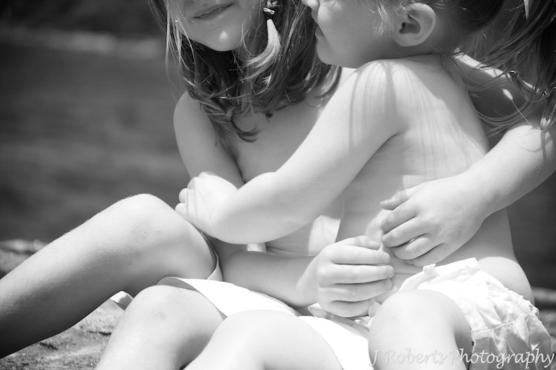 Sisters hugging arms at the beach - family portray photography sydney